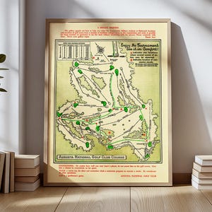 Può includere: Una mappa vintage incorniciata del campo da golf Augusta National. La mappa presenta una combinazione di colori verde e beige, con illustrazioni dettagliate del layout del campo, inclusi fairway, green e ostacoli d'acqua. Testo: "Augusta National Golf Club Course".
