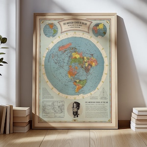 May include: Framed vintage map titled "CBS American School of the Air." The map features a polar projection of the world with continents in various colors. The frame is a light wood color, and the map includes text and a vintage radio illustration.