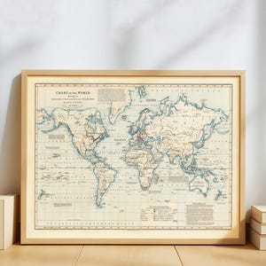 May include: A framed vintage world map with a light wood frame. The map features a cream-colored background with blue and brown details, showcasing continents and oceans. The title "Chart of the World" is visible at the top. The map is a decorative piece.
