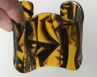 An unusual vintage curved Lucite bangle in a tortoiseshell style pattern