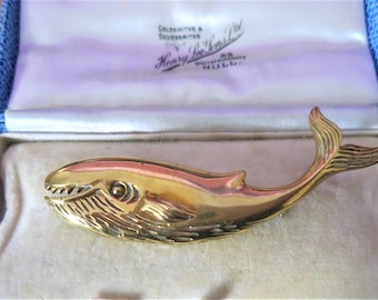 A lovely vintage gold plated/brass whale brooch