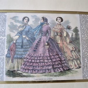 May include: A vintage illustration of three women in fashionable dresses from Paris Fashions for September. The women are wearing dresses with multiple layers of ruffles and are accessorized with hats, scarves, and flowers. The illustration is printed on paper with a text description of the fashions.