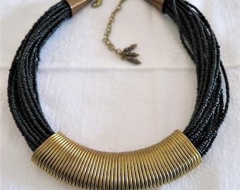 A vintage black Lucite seed bead and gold tone choker necklace