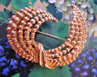 A large vintage crescent shaped gold tone brooch