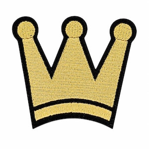 May include: A crown-shaped embroidered patch featuring a vibrant gold thread design with a thick black border. The patch displays three distinct points, each topped with a circular detail, and a curved base line, all rendered in dense stitching.