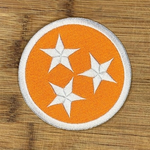 May include: Orange and white embroidered patch with three white stars in the shape of the state of Tennessee.
