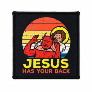 Puede incluir: Un parche cuadrado negro con un gráfico de Jesús haciendo una llave de cabeza a un diablo rojo sobre un fondo de atardecer retro. El texto JESUS HAS YOUR BACK está impreso en amarillo y naranja bajo la ilustración con textura desgastada.