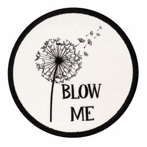 May include: A circular embroidered patch with a white background and a black stitched border. The design features a black dandelion with seeds blowing away in the wind, accompanied by the black text BLOW ME printed in a simple serif font.