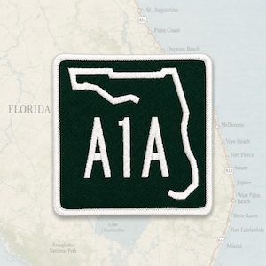 Könnte beinhalten: Ein quadratischer gestickter Aufnäher mit dunkelgrünem Hintergrund und weißem Rand. Das Design zeigt eine weiße Umrisslinie des Bundesstaates Florida und den weißen Text A1A, der mittig in der Form platziert ist und die Küstenstraße darstellt.