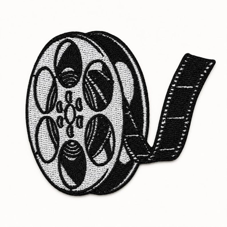 Black and white embroidered film reel patch with film strip detail centered on a square white background.