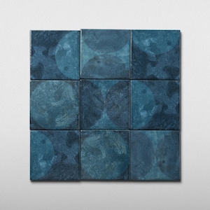 May include: Nine square tiles arranged in a 3x3 grid. Each tile is a deep teal color with a textured surface and a faded circular pattern. The tiles are set against a plain white background, creating a striking contrast.