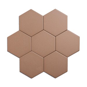 May include: Seven hexagonal tiles arranged in a flower-like pattern. The tiles are a solid, muted brown color, with a slightly textured surface. The arrangement is centered on a white background.