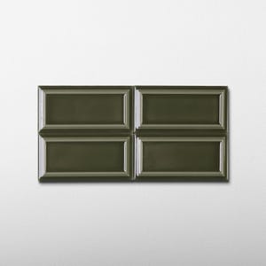 May include: Four dark olive green rectangular tiles arranged in a square pattern. Each tile has a raised, framed design. The tiles are glossy and appear to be made of ceramic or a similar material. The background is a plain white wall.