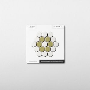 May include: A sample card featuring a hexagonal tile pattern. The tiles are a mix of white and olive green. The card has the word "SAMPLE" printed on it, along with the brand name "CEMENTO". The text "Slight variance in shade may occur between production batches" is also visible.