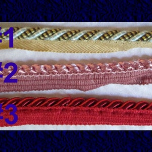 May include: Three different types of trim, labeled #1, #2, and #3.  #1 is a beige and white braided trim. #2 is a pink and white ruffled trim. #3 is a red braided trim.