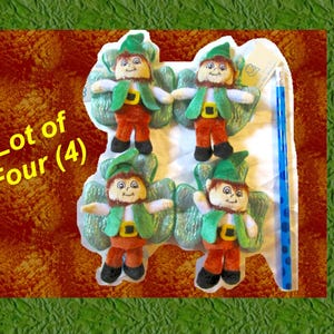 May include: Lot of Four (4) green plush leprechaun figurines with green hats and wings. Each leprechaun is wearing a green vest and brown pants.