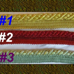 May include: Three samples of braided trim, labeled #1, #2, and #3.  #1 is a yellow braid, #2 is a red braid, and #3 is a green braid.