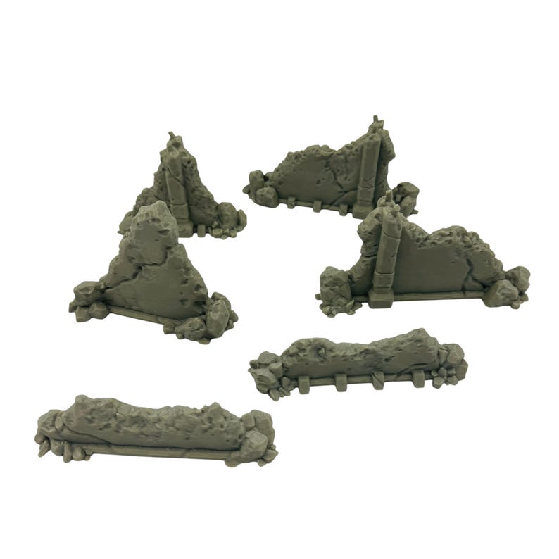 May include: A collection of gray miniature building ruins, perfect for tabletop gaming or model displays. The pieces feature detailed textures and varying shapes, including walls and fragmented structures. The overall aesthetic suggests a post-apocalyptic or historical theme.