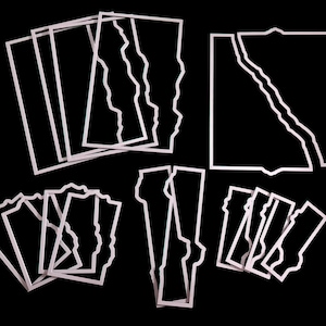 May include: A collection of light-colored metal cutting dies featuring various rectangular and square frames with jagged, torn-paper style edges. The set includes multiple sizes and shapes of frames with irregular, wavy, or deckled borders.