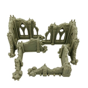 May include: A light gray miniature model of a ruined stone building with jagged edges, crumbling walls, and arched window frames. The structure features weathered textures and broken pillars, designed as a tabletop gaming terrain piece.