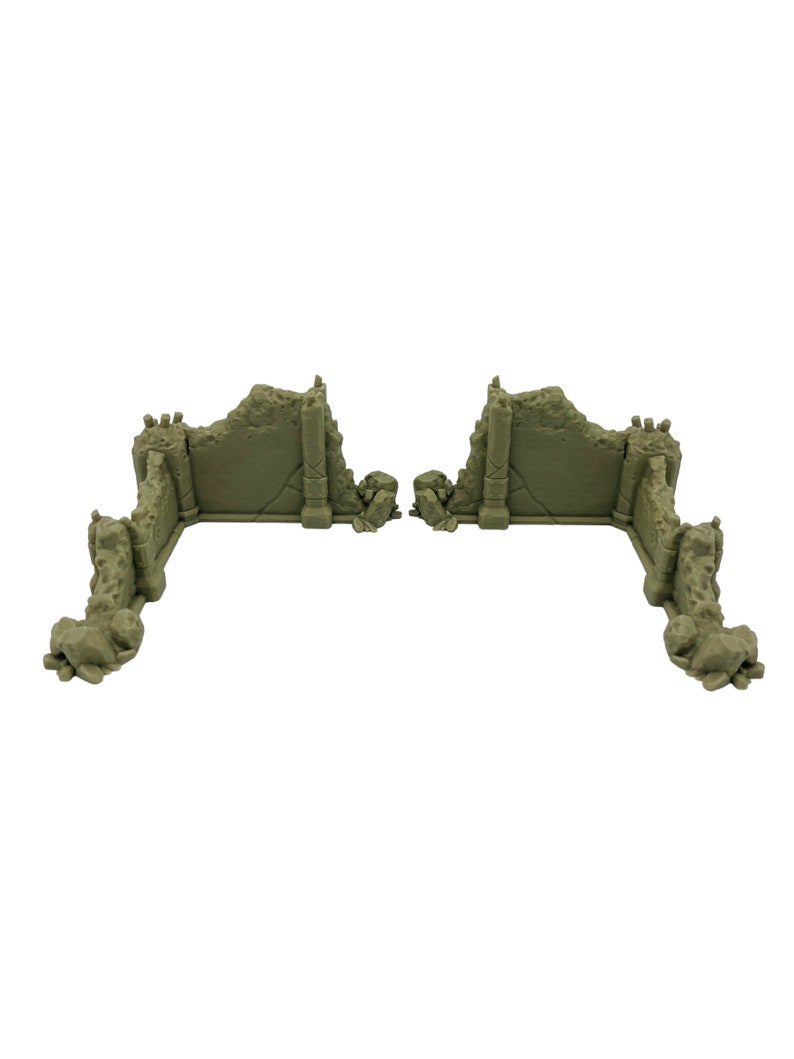 May include: Two L-shaped miniature wall sections in a light olive green color. Each piece features a jagged, ruined top edge, textured stone surfaces, and vertical pillar details at the corners, designed to look like broken masonry.