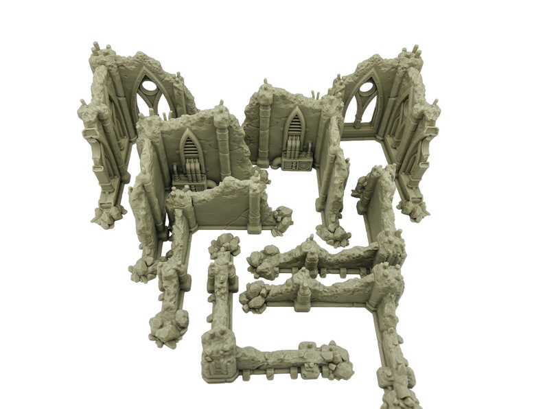 May include: A set of unpainted light gray miniature terrain pieces depicting ruined stone walls and gothic architectural structures with arched windows, textured rubble, and integrated mechanical details for tabletop gaming.