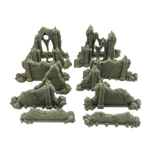 May include: A set of gray miniature ruined structures, including sections of walls and archways. The pieces are designed to resemble weathered stone, ideal for tabletop gaming or model building. The set includes various sizes and shapes for diverse terrain.