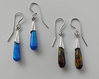 May include: A pair of silver teardrop earrings with blue and black opal stones.