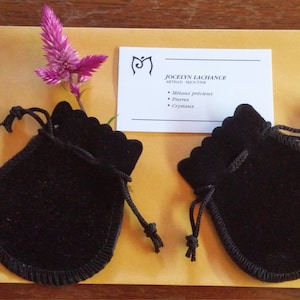 K&ouml;nnte beinhalten: Zwei schwarze Samtbeutel mit Kordelzug und einer Visitenkarte mit dem Text "Jocelyn Lachance, Medium, Reiki-Meisterin, Edelmetalle, Steine, Kristalle".