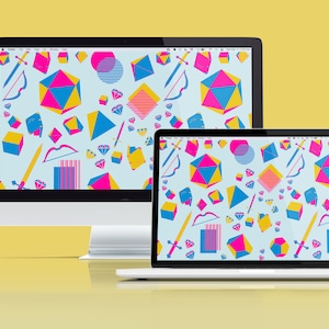 Könnte beinhalten: Zwei Computerbildschirme, ein Desktop und ein Laptop, die beide ein farbenfrohes geometrisches Muster mit blauen, rosa und gelben Formen zeigen. Das Muster enthält Diamanten, Würfel und andere abstrakte Formen.