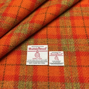 May include: Orange and green plaid fabric with two white labels that read "HAND WOVEN CLOTH Harris Tweed®" and include the text "HARRIS TWEED OUTER HEBRIDES OF SCOTLAND 100% PURE NEW WOOL".