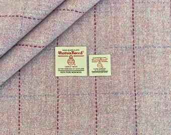 Peut inclure: Un gros plan sur un tissu en tweed rose et blanc avec une étiquette tissée qui indique "HAND WOVEN CLOTH Harris Tweed® HARRIS TWEED OUTER HEBRIDES OF SCOTLAND 100% PURE NEW WOOL".