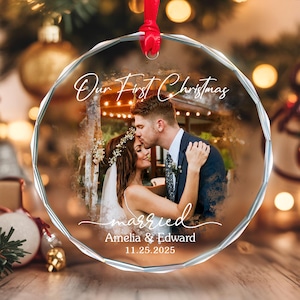May include: A clear, round Christmas ornament with a photo of a couple kissing. The ornament has the text "Our First Christmas" and "married" with the names Amelia & Edward and the date 11.25.2025.