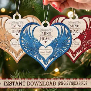 May include: Three heart-shaped wooden ornaments with angel wing designs. The ornaments are in natural wood, blue, and red. Each has the text "Always On My Mind Forever In My Heart" and "In Loving Memory James Smith 1955-2025".
