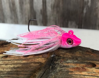 Könnte beinhalten: Pinkfarbener und weißer Angelköder mit Glitzer-Finish und pinkfarbenem Kopf. Der Köder hat einen einzelnen Haken und ein kleines Auge.