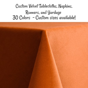 May include: A close-up of a burnt orange velvet tablecloth. The tablecloth is folded in half, showing the soft texture of the fabric. Custom Velvet Tablecloths, Napkins, Runners, and Yardage. 30 Colors - Custom sizes available!