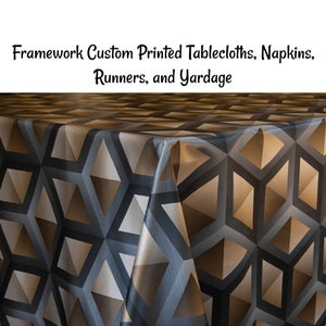 May include: A close-up of a tablecloth with a geometric pattern in shades of brown and gray. The tablecloth is made of a smooth, satin-like fabric.