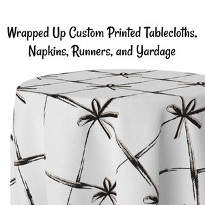 May include: White tablecloth with a black and brown print of wrapped gifts with bows. The tablecloth is made of a soft, durable fabric and is perfect for any occasion.