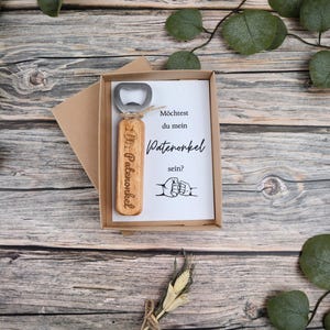 Geöffnete Geschenkbox mit der Frage „Möchtest du mein Patenonkel sein?“ und graviertem Flaschenöffner – liebevoll verpacktes Überraschungsgeschenk.