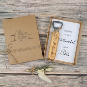 Braune Geschenkbox mit modernem Motiv auf der Vorderseite und graviertem Flaschenöffner aus Holz und Edelstahl – Geschenkset zur Patenonkel-Frage.