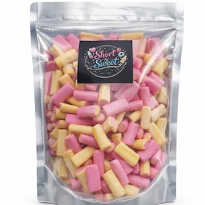 May include: A transparent bag filled with pink and yellow candy sticks. The bag features a black label with the words "Short & Sweet" and decorative elements. The candy is a mix of pink and yellow rectangular pieces.
