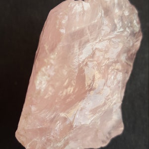 Peut inclure: Un gros cristal de quartz rose brut, translucide et brillant.