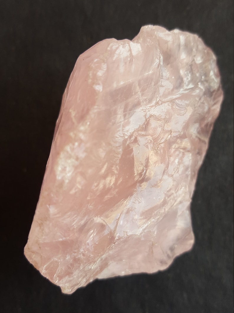 Peut inclure: Un gros cristal de quartz rose brut, translucide et brillant.