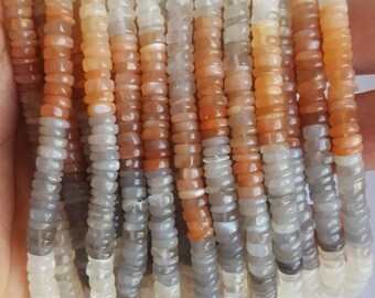 Può includere: Una collana di perle di pietra di luna multicolori. Le perle sono un mix di bianco, grigio e arancione.