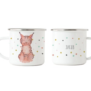 May include: Two white enamel mugs with a colourful confetti pattern. One mug features a watercolour illustration of a lynx. The other mug has the name "Jacob" written on it.