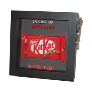 May include: A black framed box with a glass front. The box has a Kit Kat chocolate bar inside and the text "IN CASE OF EMERGENCY #mybreak BREAK GLASS".