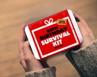 May include: A rectangular metal tin with a red and white label featuring the text 60TH BIRTHDAY SURVIVAL KIT IN A TIN and a small brown tag that reads PACKED WITH FUN. The design includes white gift box graphics on a vibrant red background.