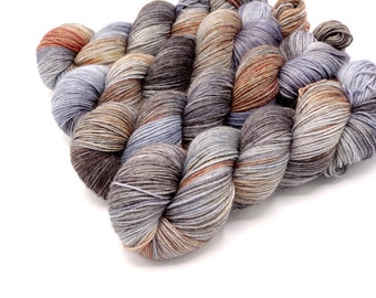 Butte // Caspian Alapaca Merino Fingering, soft variegated sock weight yarn in tones of purple, light blue, burnt orange and brown.