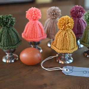 Conjunto de 6 aquecedores de ovos de tricô em formato de "gorro com pompom".