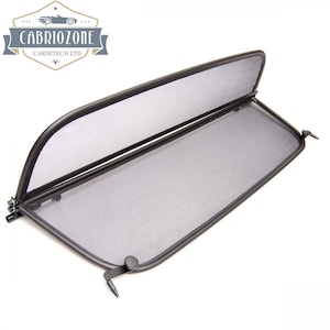 Może przedstawiać: Czarny deflektor wiatru z siatki do samochodu kabriolet. Deflektor ma czarną metalową ramę i jest przeznaczony do montażu za przednimi siedzeniami. Posiada zamek błyskawiczny dla łatwego dostępu do tylnej części samochodu.